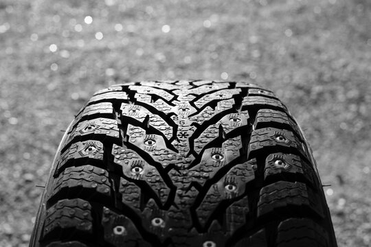 A close-up photo of a new winter tire. Focus on the center of the image. Black and white photo.