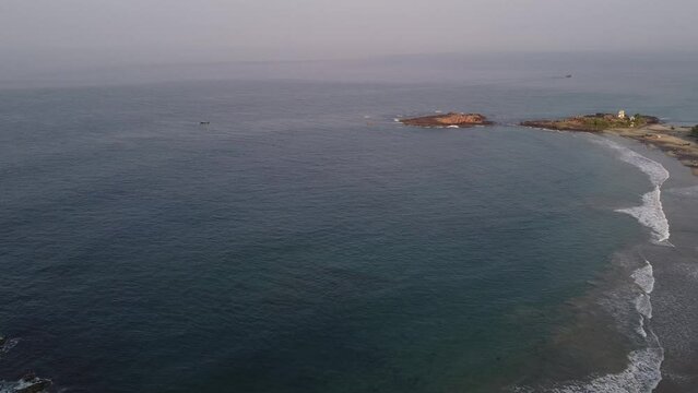 Aerial slow movement around sea waves breaking Kovallam beach