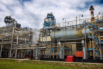 Fototapeta premium The building of the old industrial metallurgical enterprise in the summer season. A beautiful horizontal photograph of an urban landscape. 