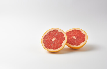 Fototapeta na wymiar Grapefruit halves on white background. The concept is a dietary fruit.