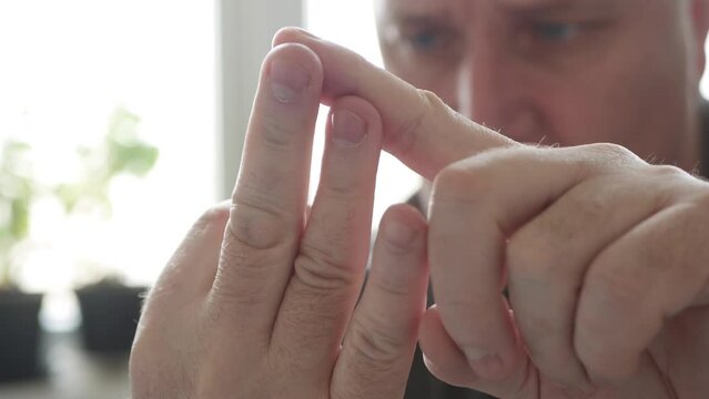 Sad Person Preoccupied Calculating Daily Income and Expenses Using Fingers from a Hand. Man Numbering Something Using His Fingers.