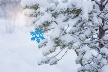 snow-covered pine trees in the forest, Christmas decoration snowflake, frost and snow caps on the...