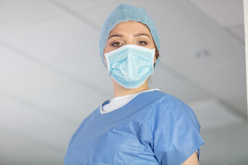 Fototapeta na wymiar woman doctor in cap and face mask in surgery room