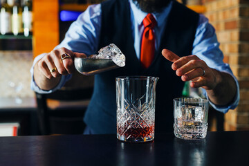 close up bartender adding ice in glass