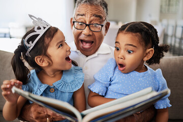 Family, reading book and children with grandpa for wow, surprised and excited expression in a living room with people bonding. Grandfather or man, kids and story time at home with man and girls - obrazy, fototapety, plakaty