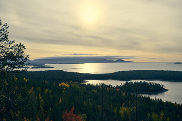 Naklejka na ściany i meble Forest lake surrounded by autumn foliage at sunset.