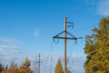 Power lines on the background of the blue sky close-up. Electric hub on a pole. High voltage wires