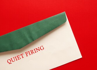 Green envelope on red background with text written QUIET FIRING, when employer creates situation that forces creates situation or make working conditions miserable to  forces employee to resign