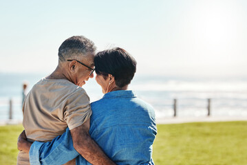 Hug, love and senior couple at the beach for a holiday in Brazil during retirement in summer. Back of a relax, happy and elderly man and woman hugging with affection on a travel vacation by the sea