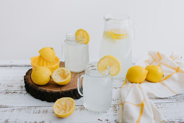 lemonade drink with yellow lemons or lime on Jar and glass on white background in Latin America	