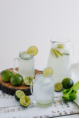 lemonade drink with green lemons or lime on Jar and glass on white background in Latin America	

