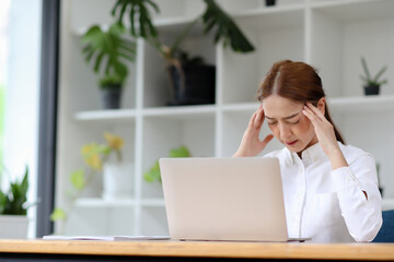 Business Asian woman  are stressed at work in the office. Asian beautiful woman feels uncomfortable working. Which is caused by stress, accumulated from unsuccessful work And less resting body.