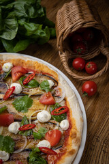 pizza with eggplant, cheese, tomatoes and chili peppers in a restaurant
