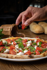 pizza with eggplant, cheese, tomatoes and chili peppers in a restaurant
