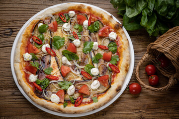 pizza with eggplant, cheese, tomatoes and chili peppers in a restaurant
