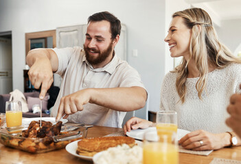 Family, food and man cutting chicken at dinner party with woman smiling, eating and drinking...