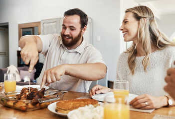 Family, food and man cutting chicken at dinner party with woman smiling, eating and drinking together in dining room. Happy, care and celebrate, share time with couple and friends in home in Canada.