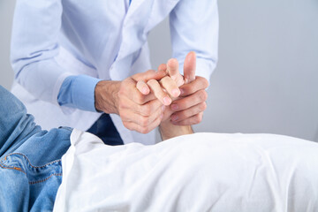 Caucasian doctor massaging patient hand.