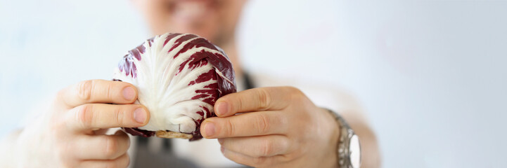 Male blogger with organic and purple vegetable in kitchen, healthy vegetarian food blog