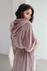 Young healthy serene woman girl relaxing in bathrobe and spa towel after having bath shower at home. Beauty treatment, rest and body care procedures.