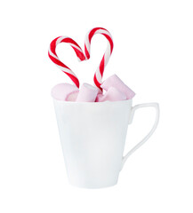 pink marshmallow in white cup with candy canes in heart shape isolated on white. Christmas, birthday card concept.