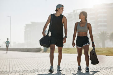 Sports, personal trainer and woman in fitness walking with a soccer ball for cardio exercise, workout and training session. Smile, wellness and happy couple enjoy a healthy city lifestyle in summer