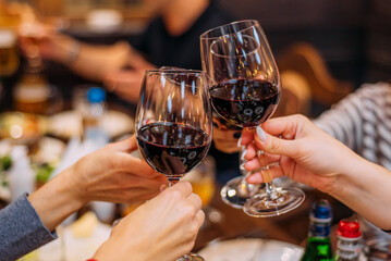 Glasses with wine. Toast. A group of friends are celebrating a holiday.