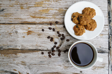 Black coffee cup with cookies on wooden floor, black coffee in the morning to drink with cookies.