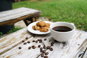 Black coffee cup with cookies on wooden floor, black coffee in the morning to drink with cookies.