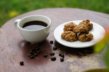 Black coffee cup with cookies on wooden floor, black coffee in the morning to drink with cookies.