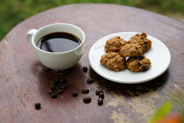 Black coffee cup with cookies on wooden floor, black coffee in the morning to drink with cookies.