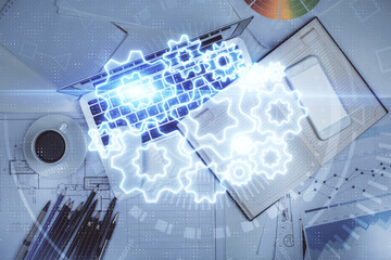 Business theme hologram drawings over computer on the desktop background. Top view. Multi exposure. Concept of international connections.