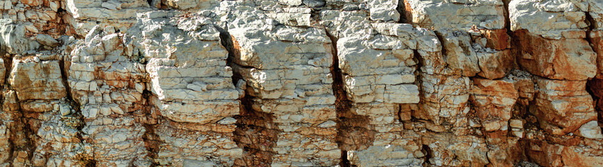 Grungy cragged bumpy pitted cavity stone facade, split layer gap.Ruined cracked shattered worn rough hiking canyon.Old ragged grunge steep marble cliff. Grand vintage crannied damaged impressive gorge