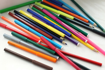 Set of colored pencils and felt-tip pens, preparation for school, many different pencils on white background, close-up