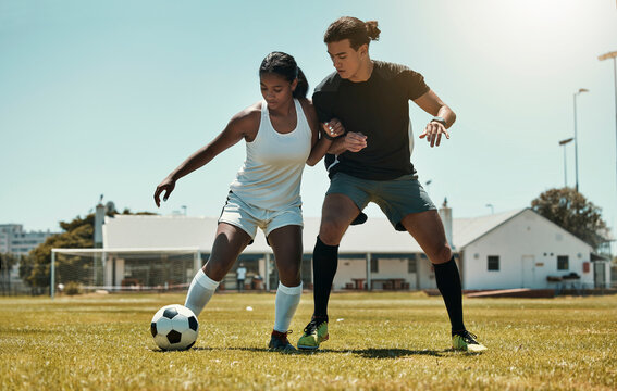 Man, woman and playing soccer on grass park, stadium field and nature environment in competition match, game and challenge. Fitness friends, sports people and football players in soccer ball training