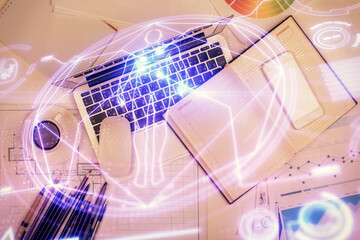 Education hologram drawings over computer on the desktop background. Top view. Multi exposure.