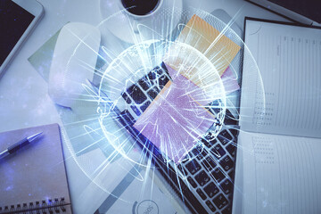 Business theme hologram drawings over computer on the desktop background. Top view. Multi exposure. Concept of international connections.