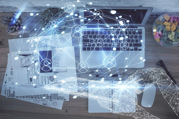 Social network hologram drawings over computer on the desktop background. Top view. Double exposure.