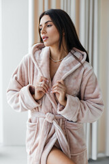 Young healthy serene woman girl relaxing in bathrobe and spa towel after having bath shower at home. Beauty treatment, rest and body care procedures.