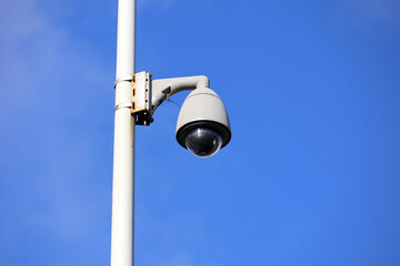 Outdoor surveillance video camera on a street pole in blue sky. Cctv camera, concept for security,...