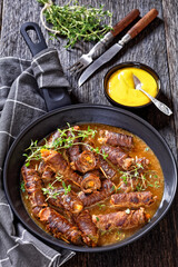 german beef rouladen in thick gravy on pan