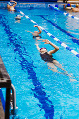 latin young man swimmer athlete wearing cap and goggles in a swimming training holding On Starting...