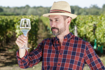 winemaker tasting white wine in vineyard