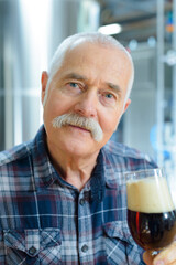 senior gentleman tasting craft beer