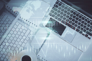 Financial market graph and top view computer on the desktop background. Multi exposure. Investment concept.