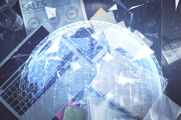 Business theme hologram drawings over computer on the desktop background. Top view. Multi exposure. Concept of international connections.