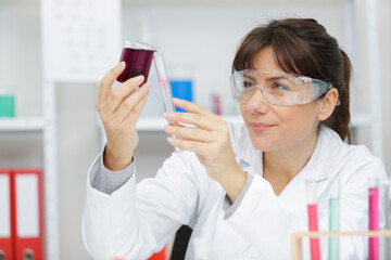 woman scientist adding liquid to test tube