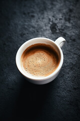 Cup of coffee on dark stone background. Close up. Copy space.