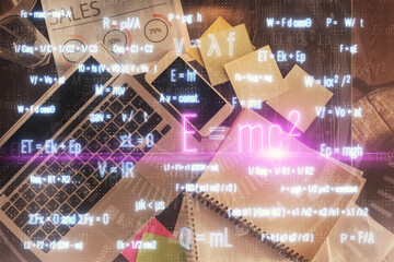 Physics and math theme hologram with formula drawings over computer on the desktop background. Top view. Multi exposure. Concept of education.