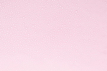 Water drops on tender pastel soft light pink background as pattern of tiny glossy shine drops as...